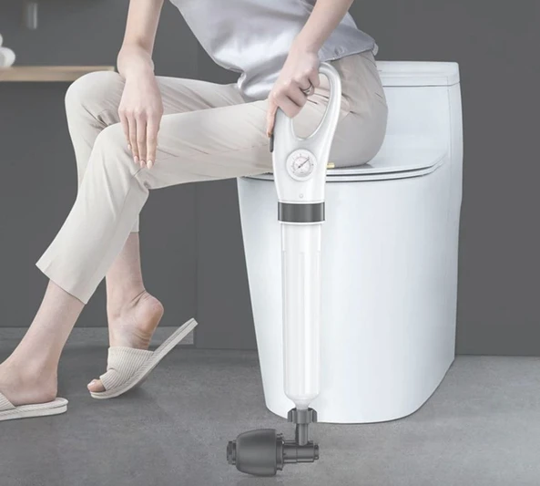 Image of woman sitting on the toilet, holding the Plunge Blaster